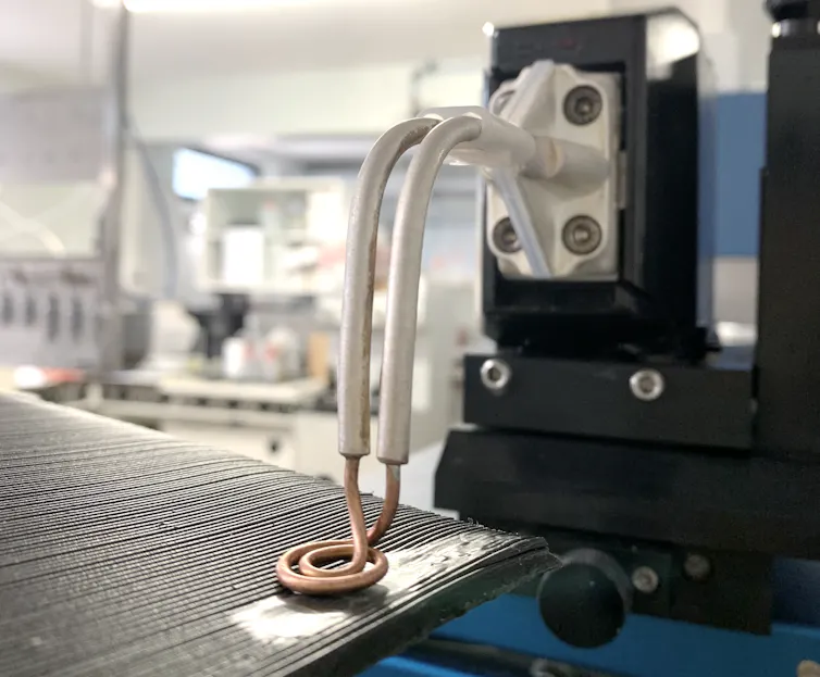 Le bras de l’inducteur est placé au dessus de la plaque de plastique, qui devient lisse et brillant, là où il est encore rainuré autour