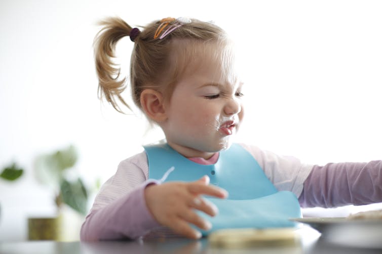 Toddler wearing bib with food smeared on face