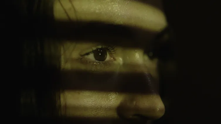 A woman's face, half in shadows.