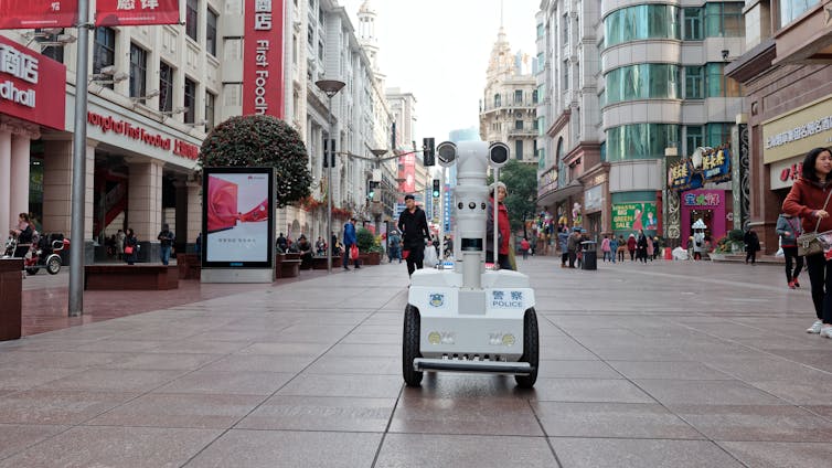 A robot police officer drives down a street in China.