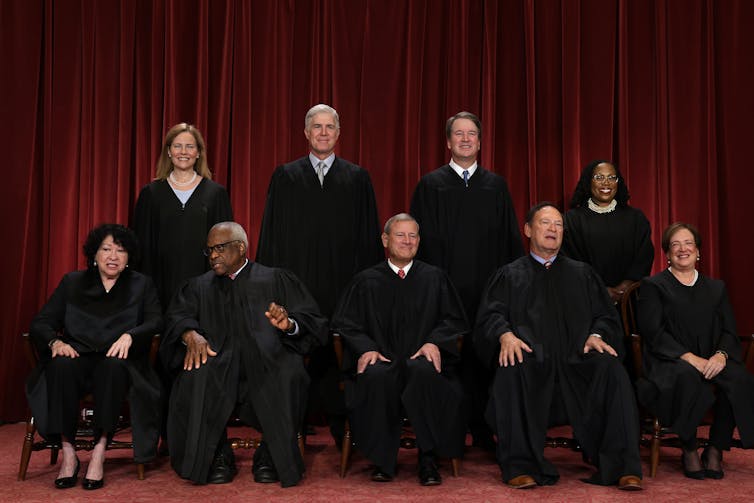 The nine members of the Supreme Court, as of 2024, seated and standing in a group.