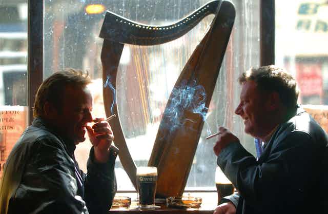 Two men smoking in a pub.