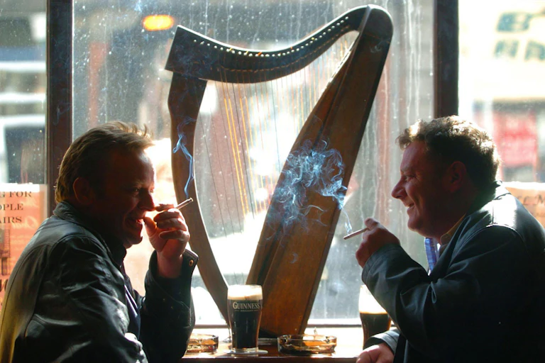 Two men smoking in a pub.