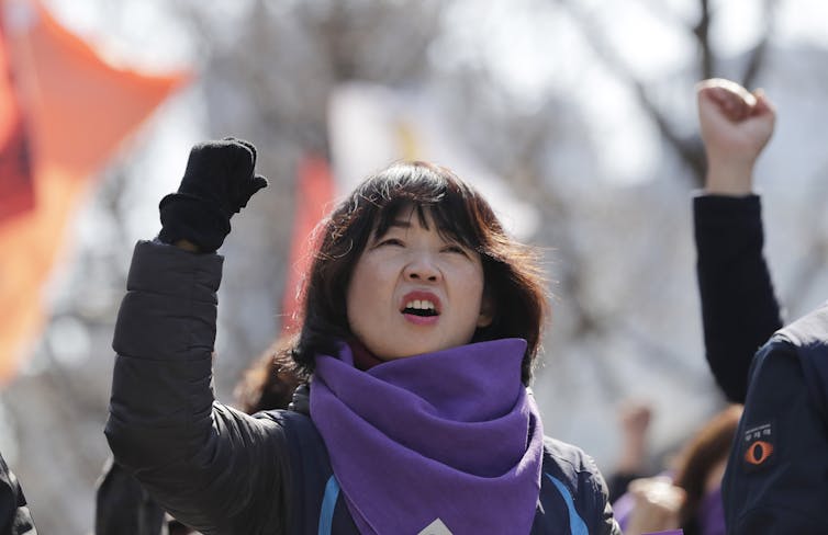 한 여성이 정치 집회에서 주먹을 휘두르고 있다.