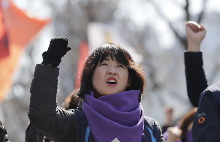 Woman at political rally shakes her fist in the air.