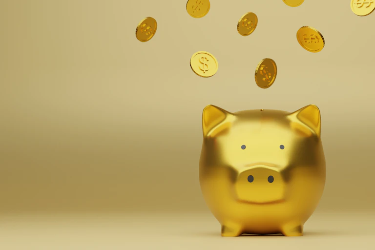 A golden piggy bank with gold coins flying around it.