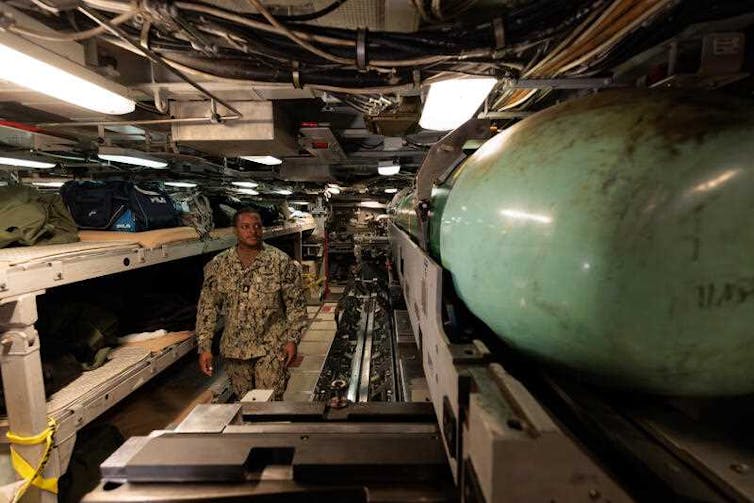 A US military officer stands inside a submarine