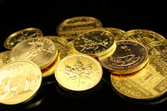 Коллекция канадских золотых монет на черном фоне.
