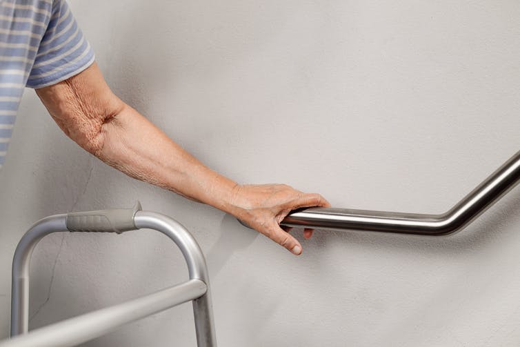 Older person holding a stabilising bar