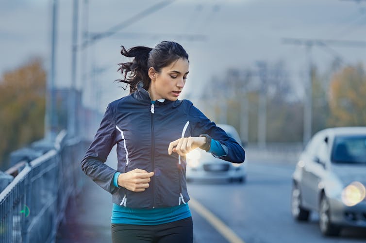 Woman runner using smart watch.
