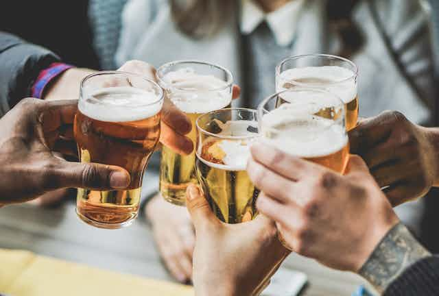 Five beer glasses clinking in a toast