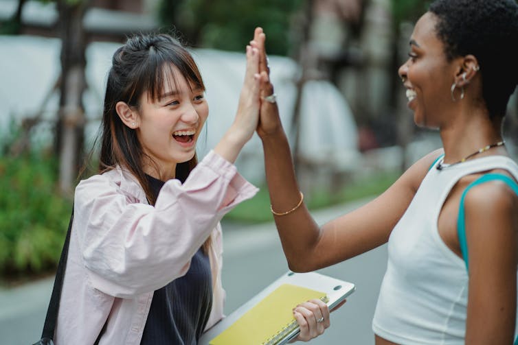 Two people high-fiving each other.