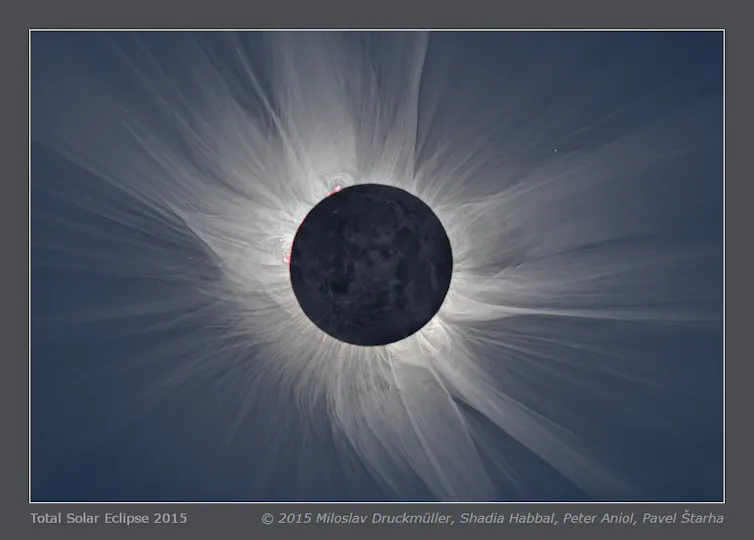 un cercle noir entouré d’une lumière blanche diffuse sur un fond bleu marine