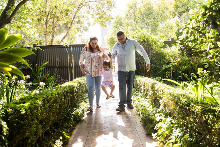 Kinship carers walk with First Nations child into their home