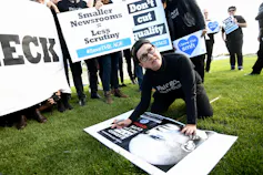 A woman signs a placard at a protest.
