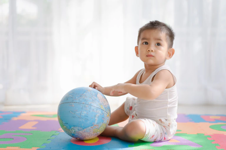 Un enfant tient un globe terrestre.