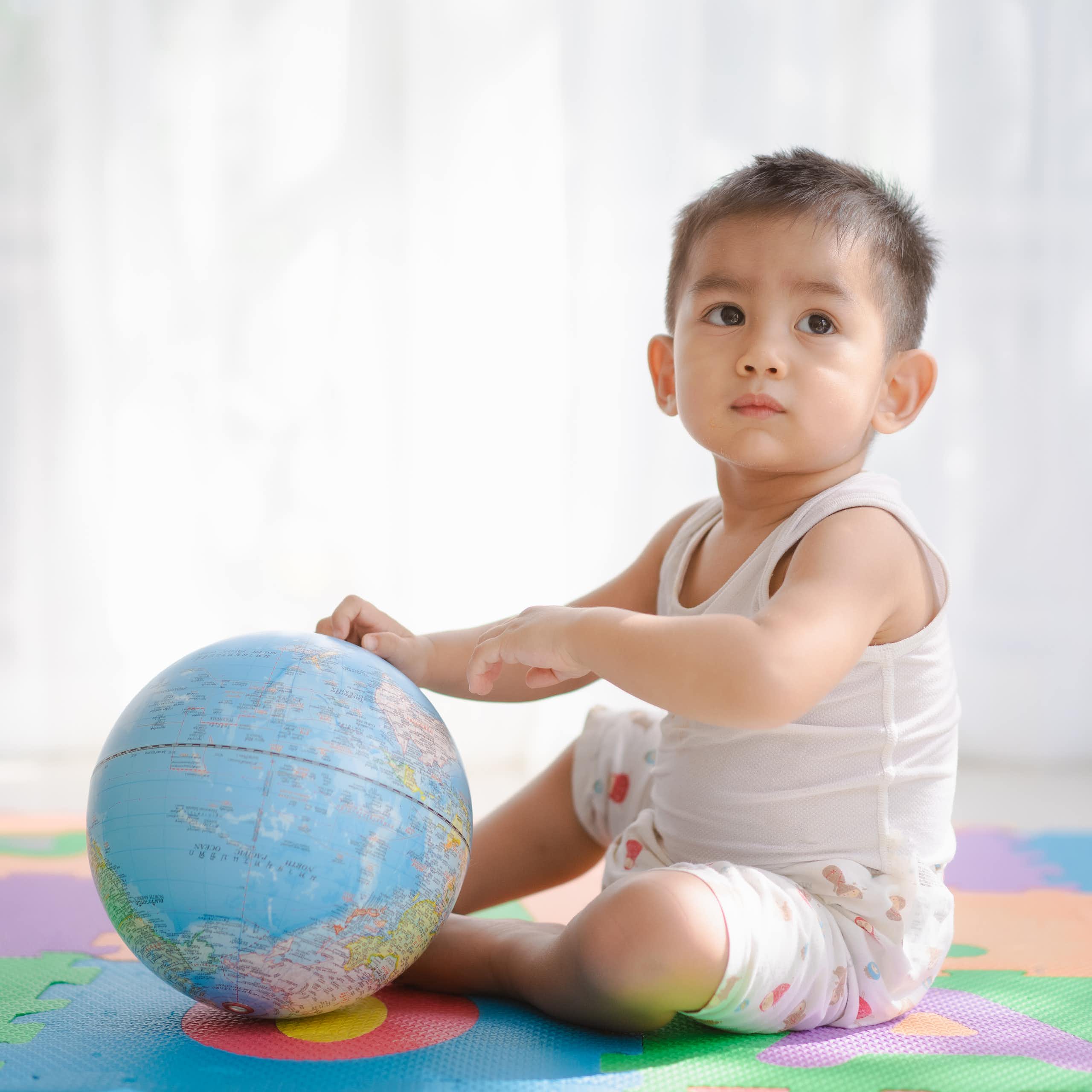 Un enfant tient un globe terrestre.
