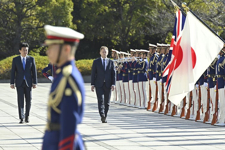 Britain's Defense Minister Grant Shapps (C) walks with Japanese Defense Minister Minoru Kihara (L) as he reviews an honour guard ahead of a bilateral meeting at the defense ministry in Tokyo, Japan, 14 December 2023