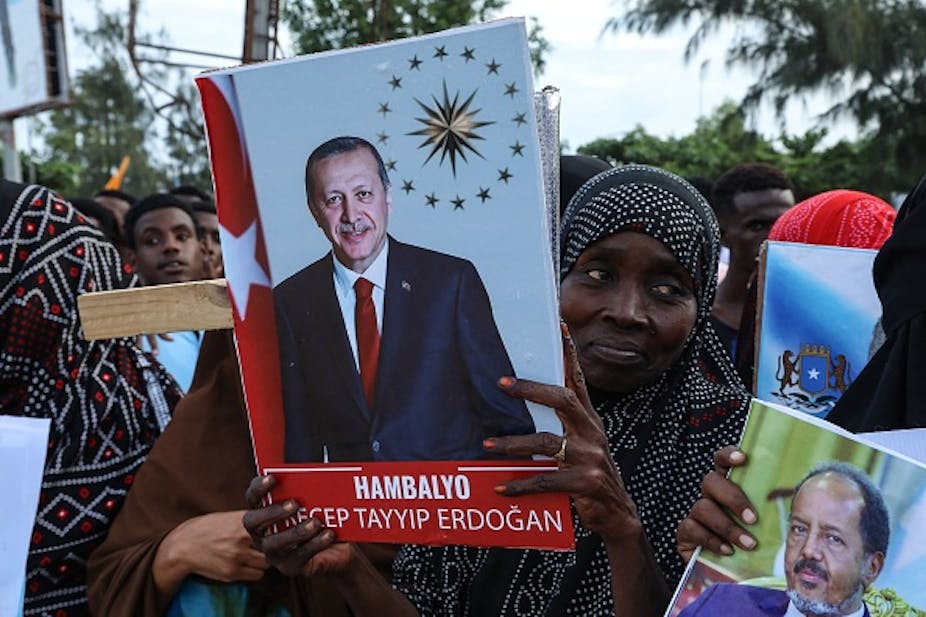 A woman in a group holding posters of President Recep Tayyip Erdogan and his Somalia counterpart Hassan Sheikh Mohamud 