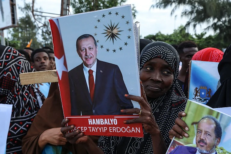 A woman in a group holding posters of President Recep Tayyip Erdogan and his Somalia counterpart Hassan Sheikh Mohamud