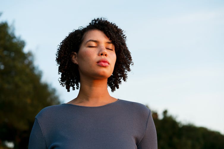 woman with her eyes closed breathing calmly