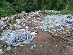 Plastic waste by a river bank