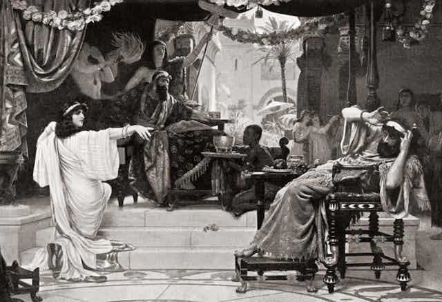 A black and white drawing of a woman in white robes pointing her finger at a recoiling, seated man with a beard.