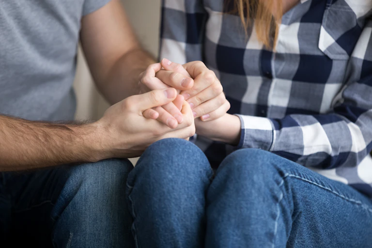 A man and woman hold each other's hands.
