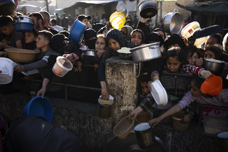 a group of people hold out metal pots