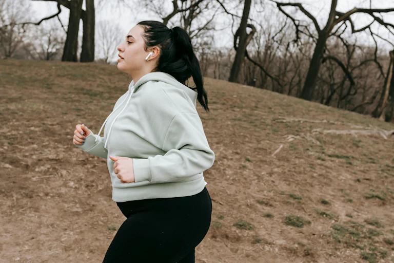 Woman jogs through parkland