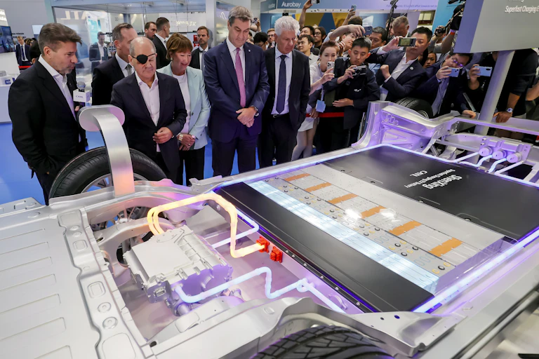 people looking at battery pack of electric vehicle