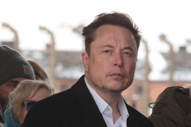 Face of a man with heads of others around him, looks into distance