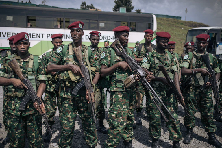 Men dressed in military fatigues and holding guns standing in front of a bus