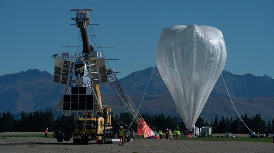 SuperBIT with a giant helium balloon in the background, and New Zealand's mountains behind that.