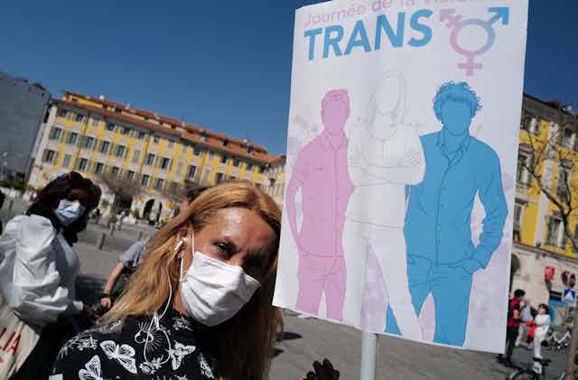 Une personne transgenre tient une pancarte alors qu'elle participe à la «Journée internationale de la visibilité des transgenres»  à Nice,  le 31 mars 2021.