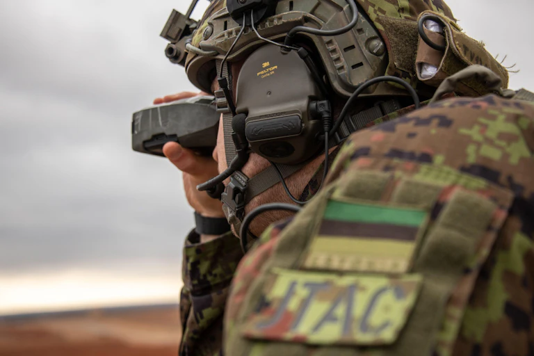An Estonian tactical air control party specialist looks into the distance.