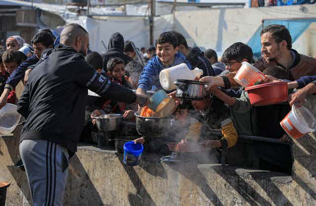 A man dishes out food to refugees in Gaza, January 2024.