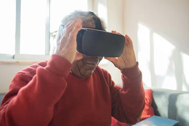 A senior man wearing VR goggles.