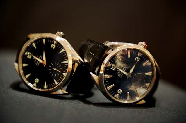 Two watches with clock faces showing the two times before and after daylight saving changes