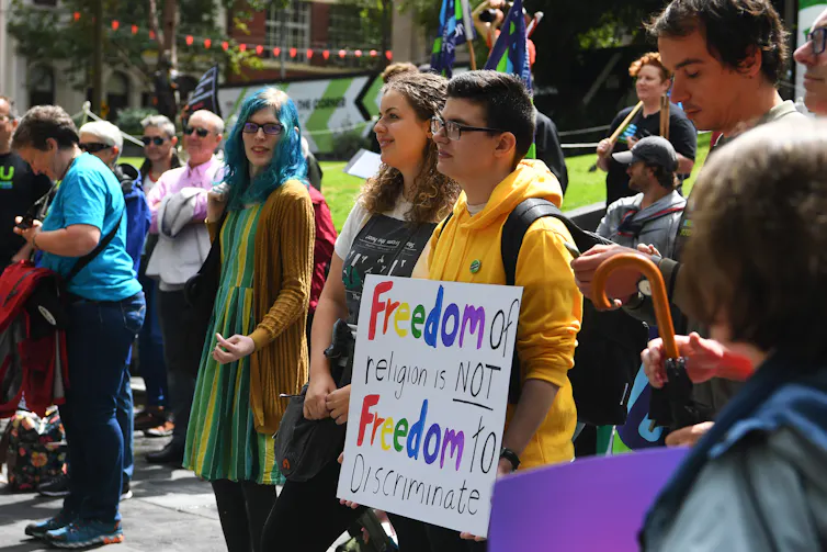 People at a protest, carrying signs.