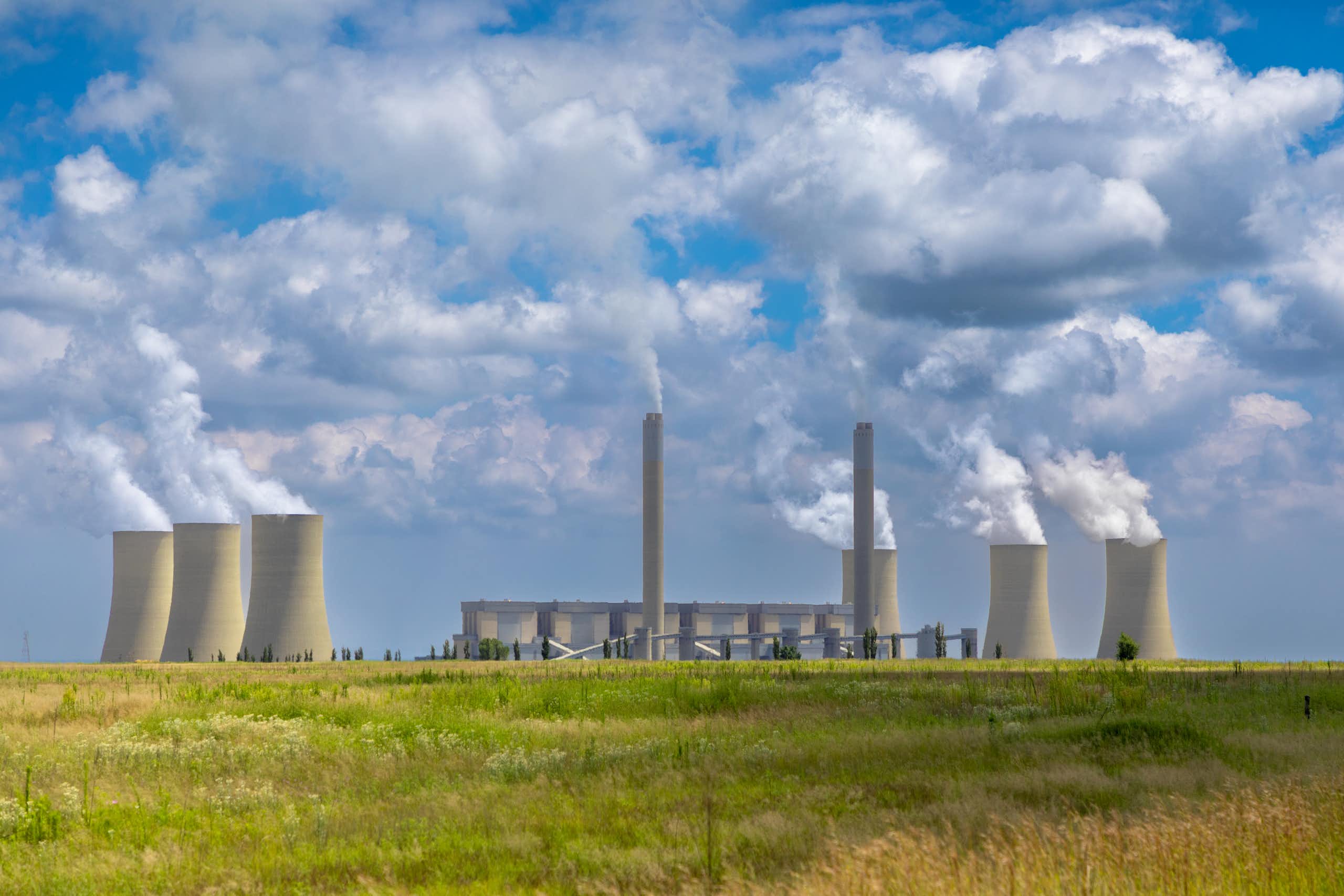 Distant view of concrete towers in a landscape, with vapour rising from them