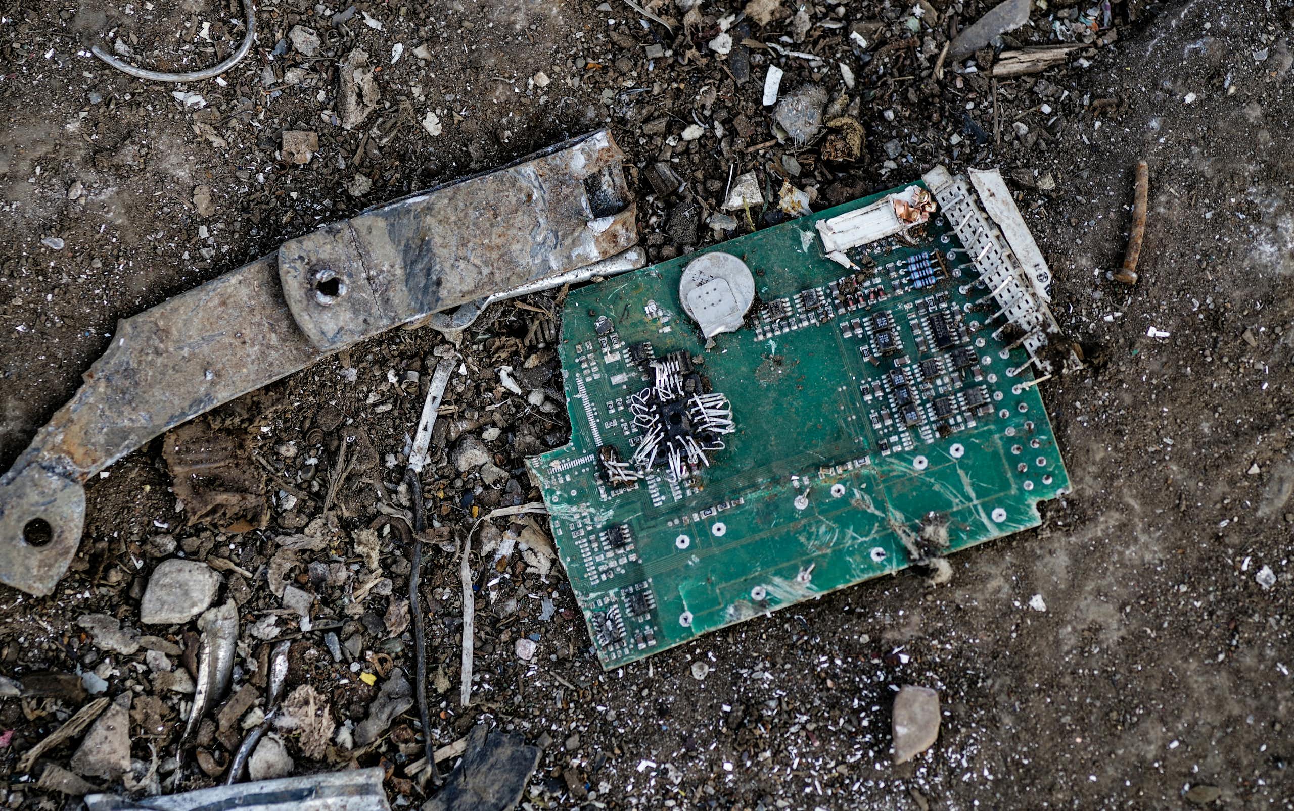 Un circuit imprimé et d'autres déchets métalliques, sur un sol de terre