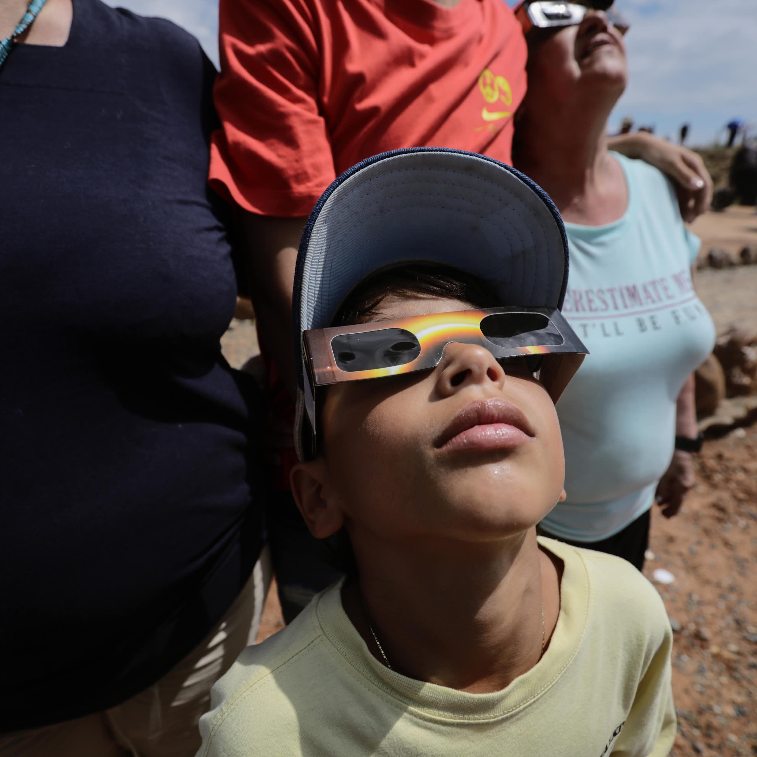 A young boy wearing protective glasses looks skyward.