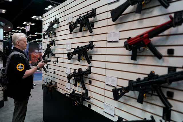 A man examines a gun at a National Rifle Association convention held in Indianapolis, Indiana, in 2023.