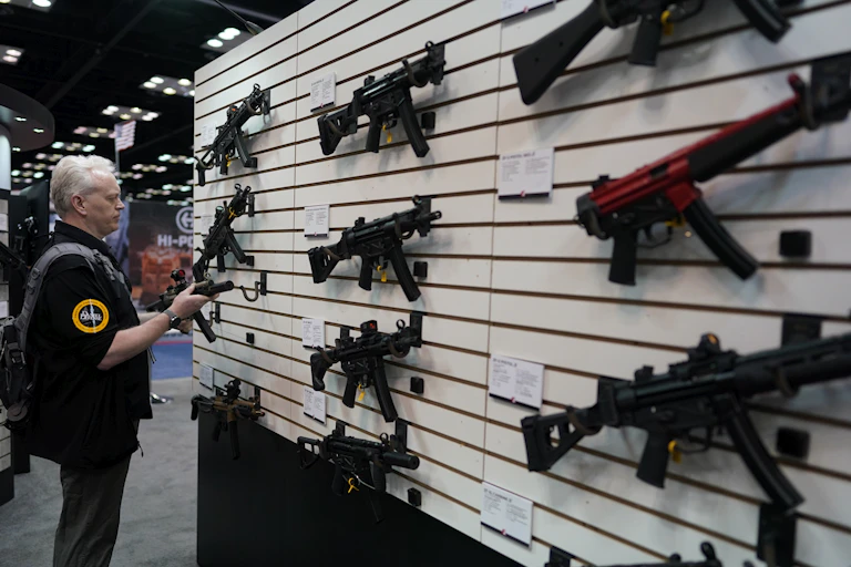 A man examines a gun at a National Rifle Association convention held in Indianapolis, Indiana, in 2023.