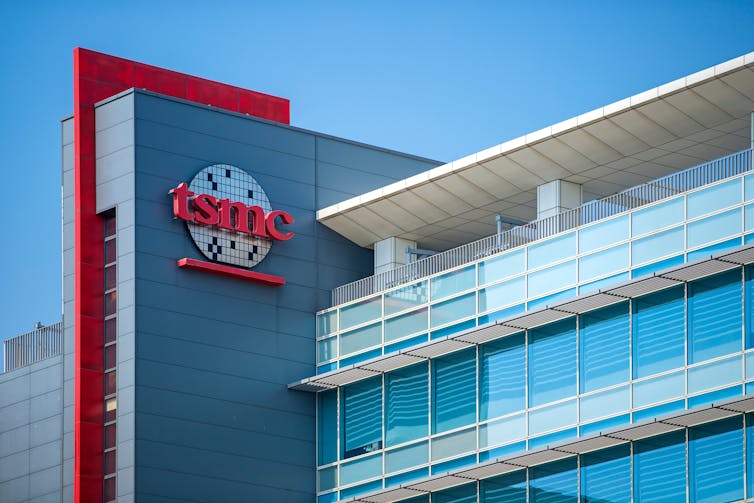 A glass-fronted building with a sign on it that says tsmc