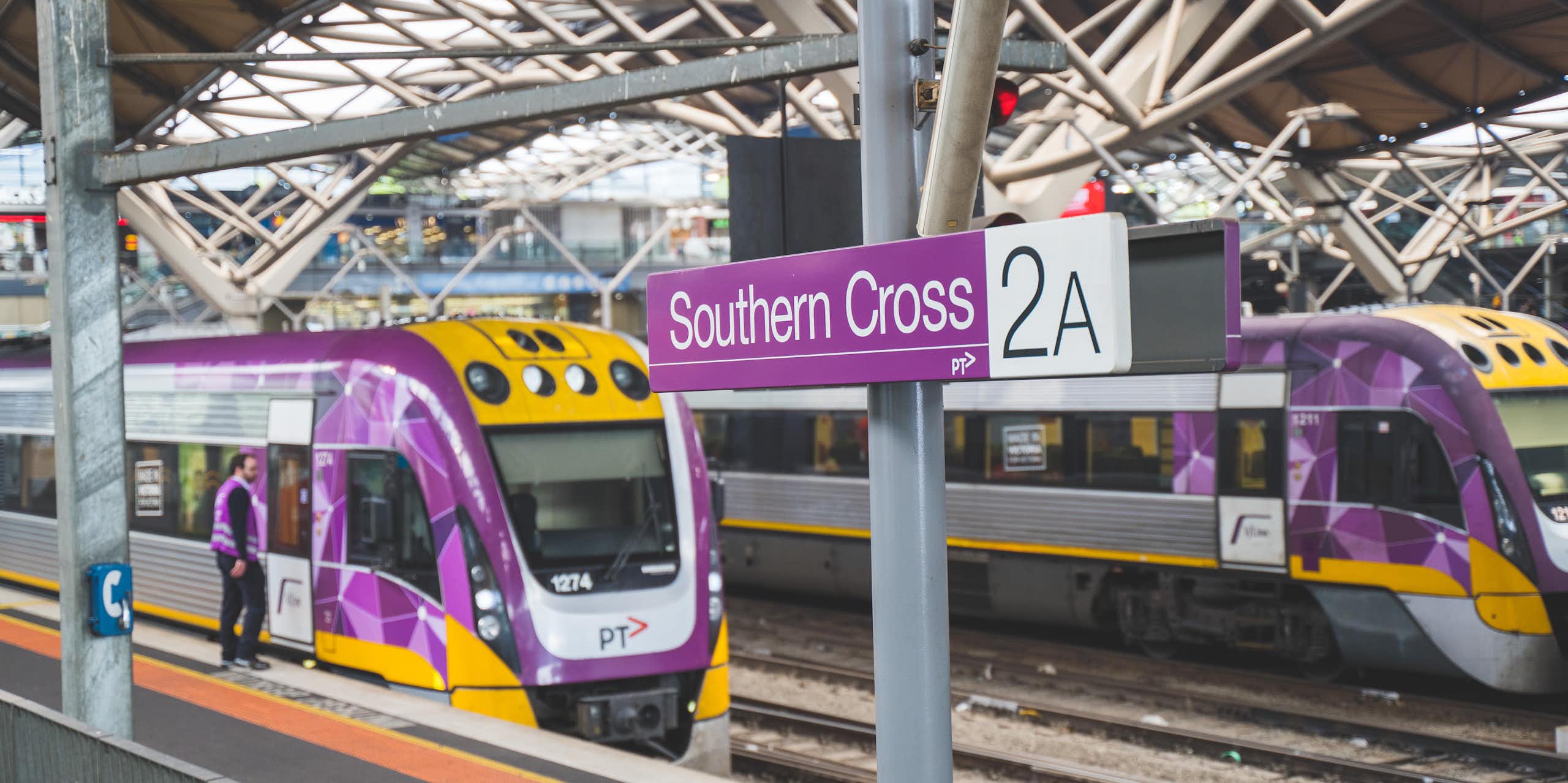 Two V/Line trains at platforms under the roof of Southern Cross Station