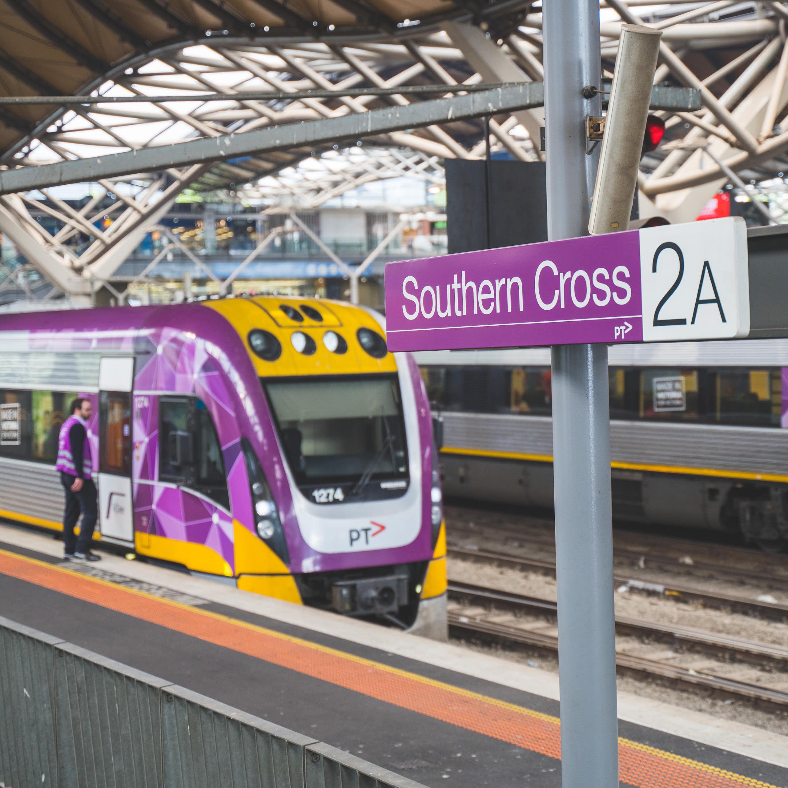 Two V/Line trains at platforms under the roof of Southern Cross Station