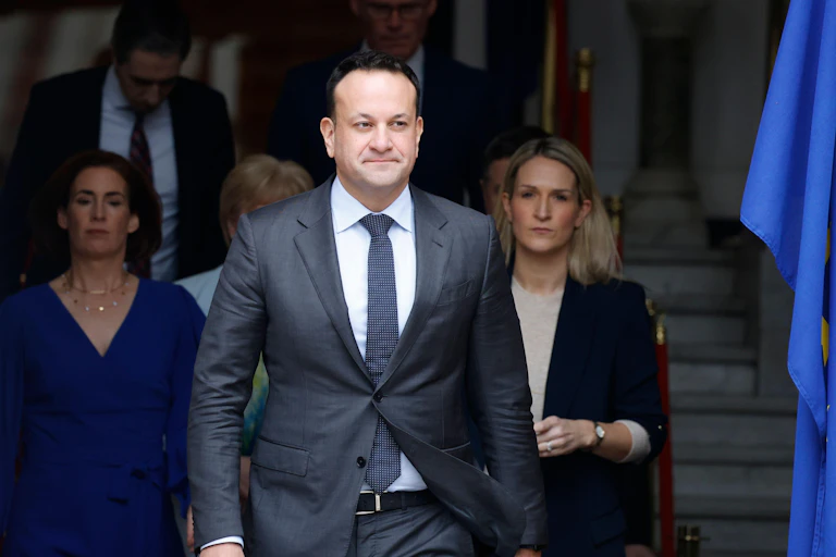 Leo Varadkar walking out of a building with a team of people behind him