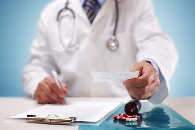 A doctor handing over a prescription